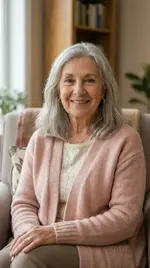 Portrait of Linda H a warm woman with shoulder length gray hair wearing a soft pink cardigan